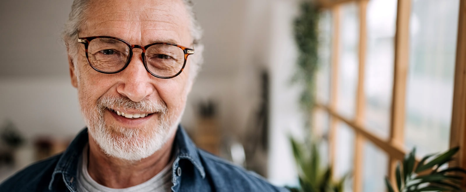 Man with glasses smiling in home