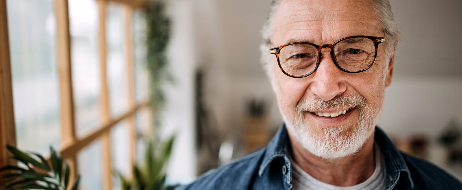Man with glasses smiling in home