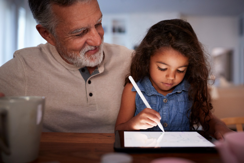 Grandfather reviewing the differences between banks & credit unions with his granddaughter.