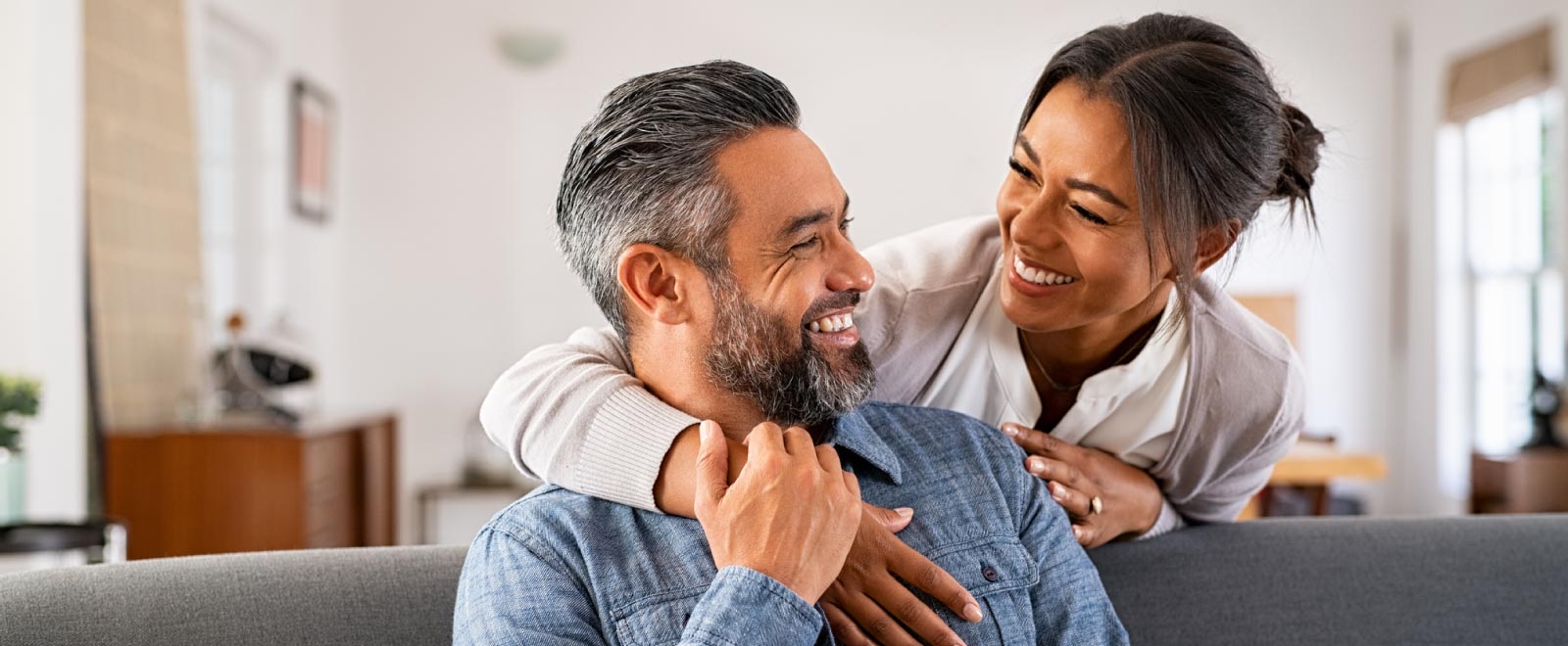 A man and woman smiling at one another.
