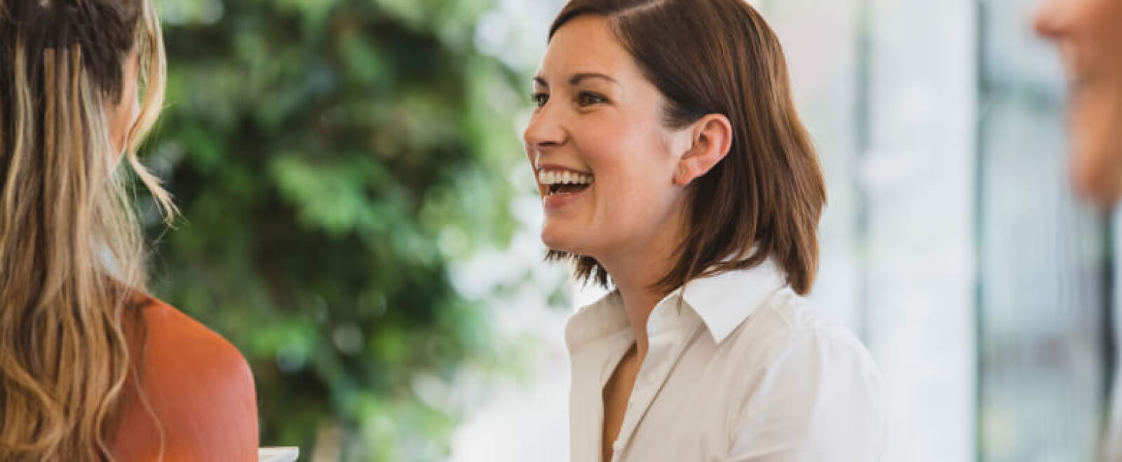 Two female coworkers laugh.