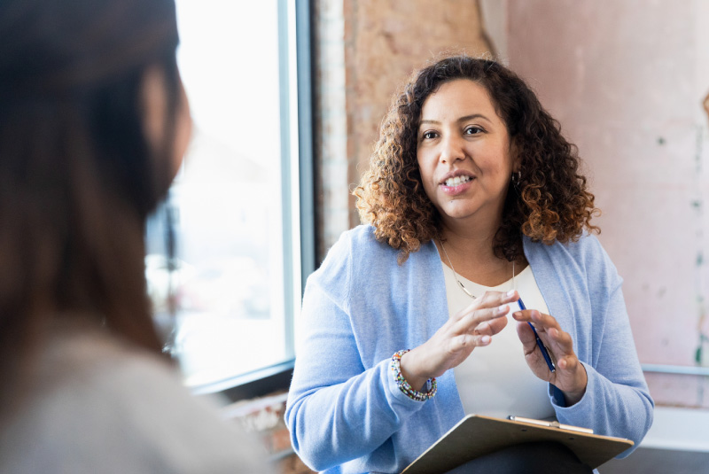 Two women talking and one women is explaining something to the other.