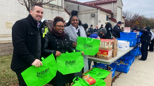police and KEMBA volunteers deliver Thanksgiving supplies to families in need