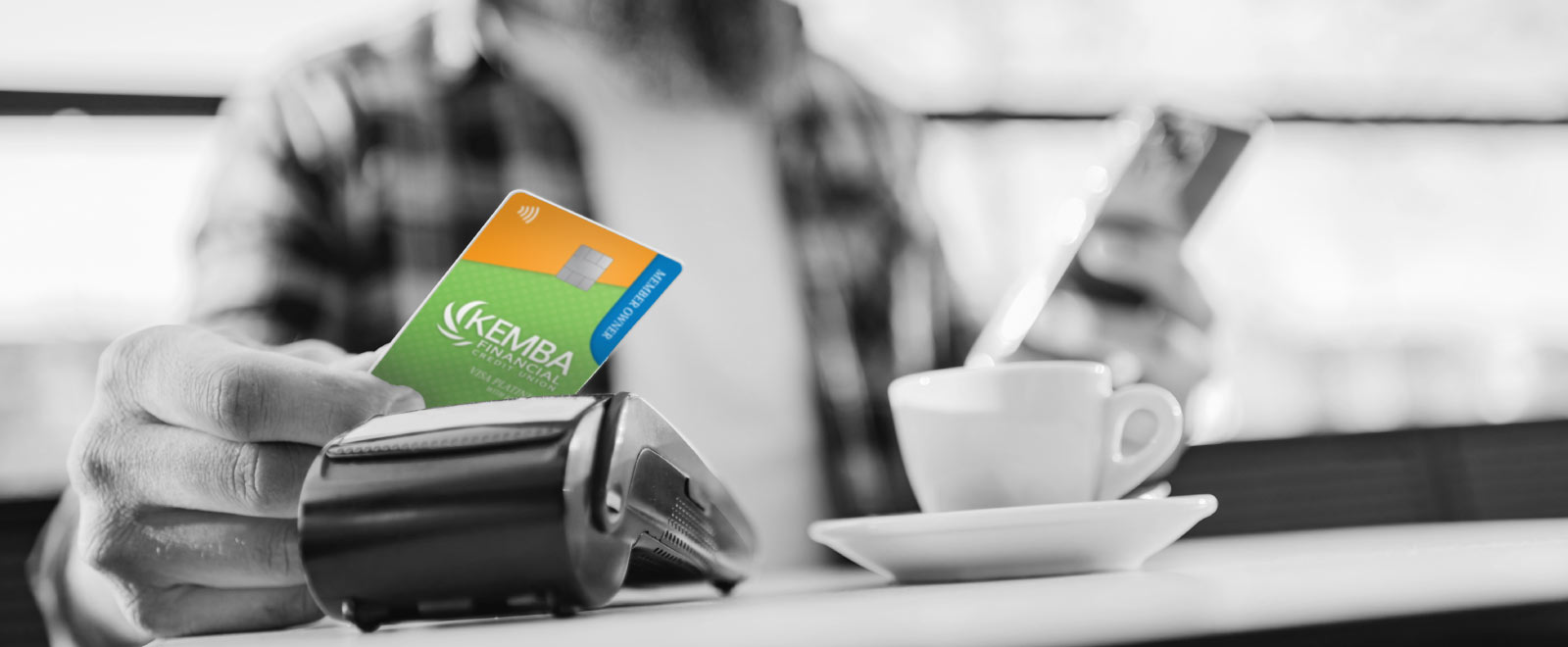 Man using the KEMBA Platinum Credit Card at a local coffee shop, earning cash back points
