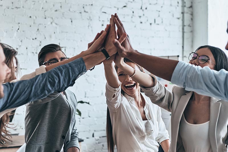 A group of people putting all of their hands together.