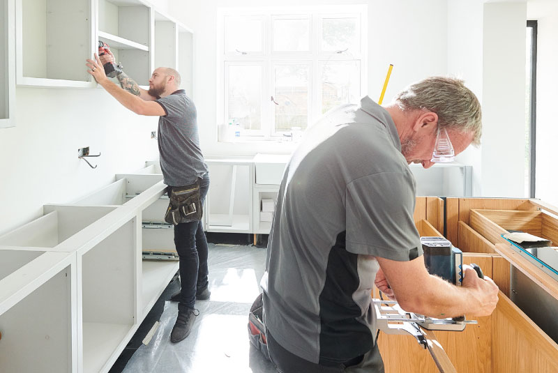 two construction workers remodeling a kitchen