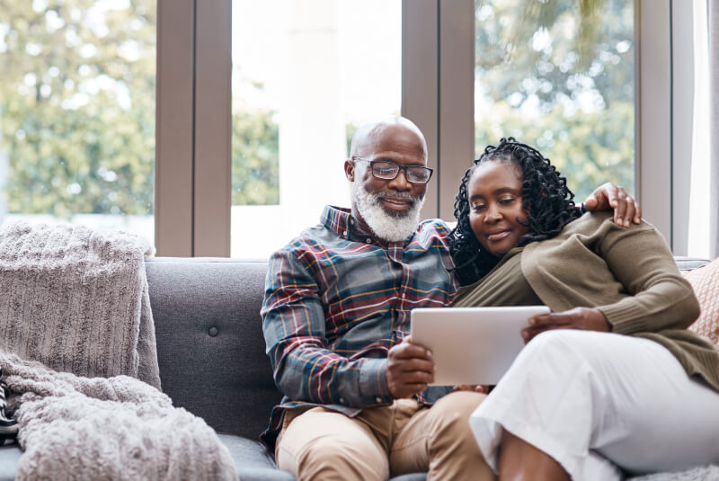 mature family using tablet and hugging on the couch