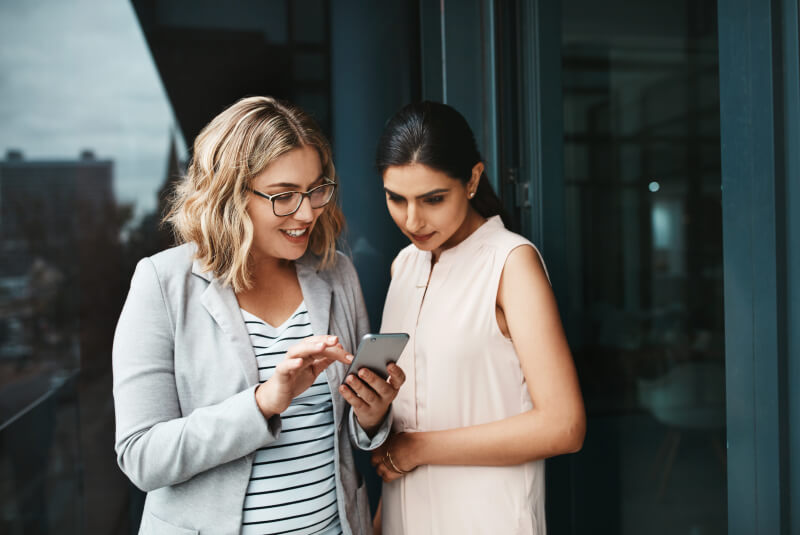 two woman using cell phone