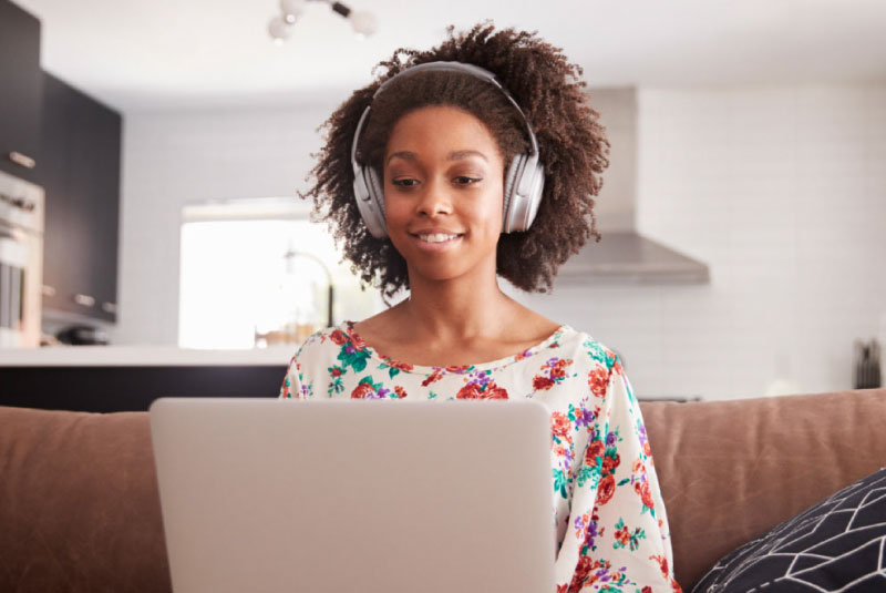 young woman using computer and listening to headphones