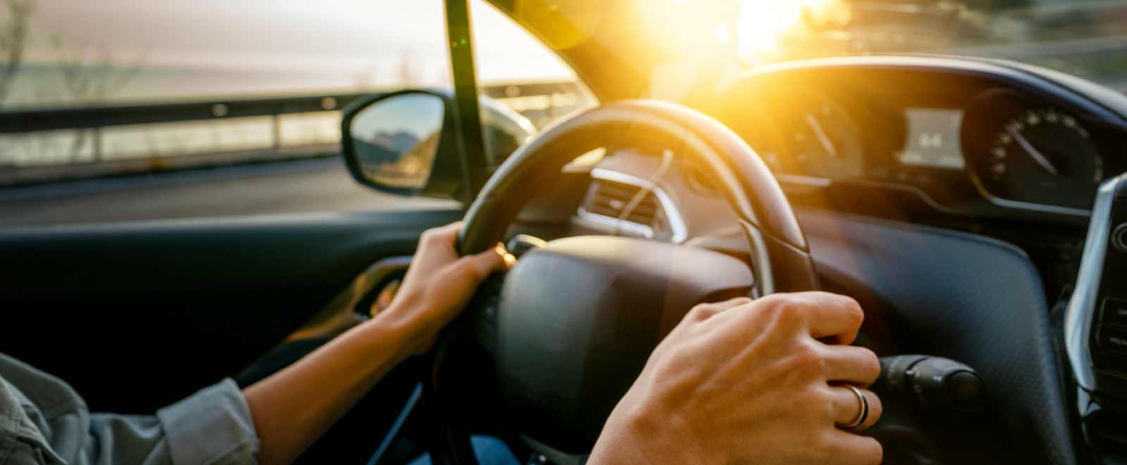 Woman driving confidently after a KEMBA auto loan refinance
