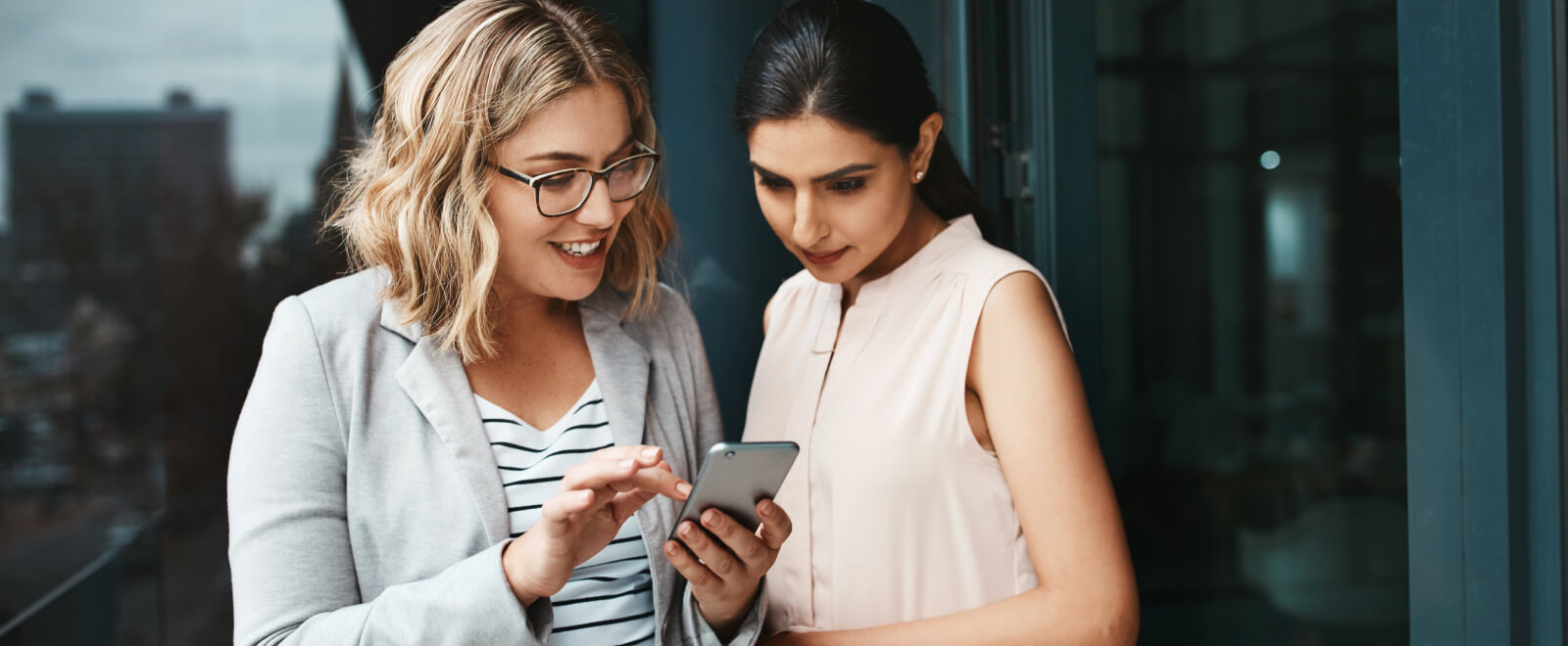 Two young females looking at a mobile phone.