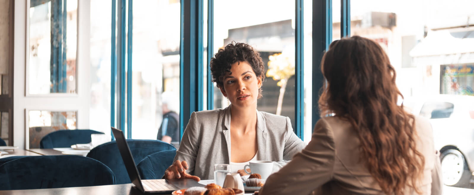 Two women sitting at a table in a business meeting.