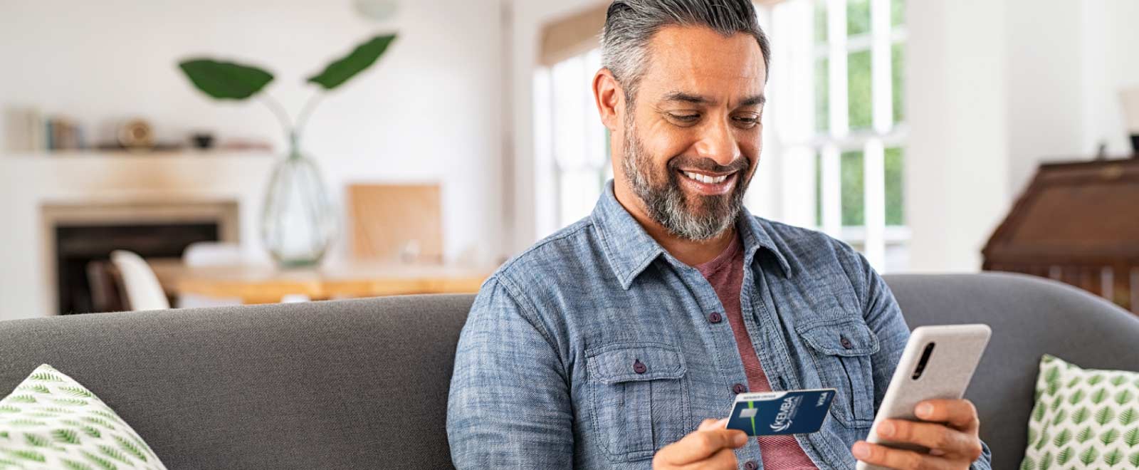Man excitedly holding a credit card, thrilled about a cash back promotion.
