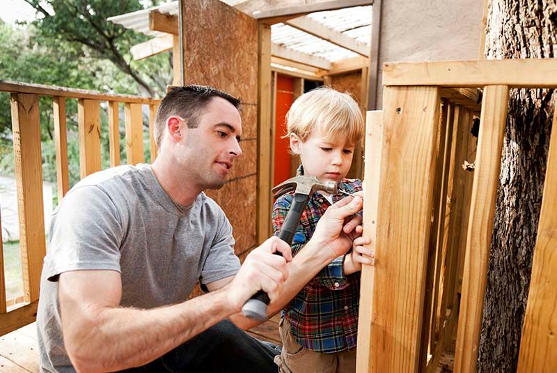 father and son building treehouse