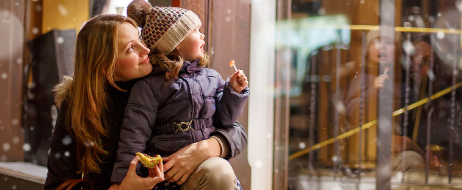 mother and young child window shopping during winter holidays