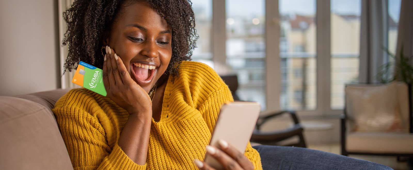 Woman excitedly holding a credit card, thrilled about a balance transfer intro rate promotion.
