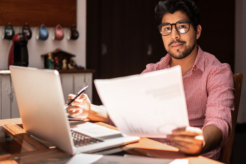 hopeful man reviewing finances on computer