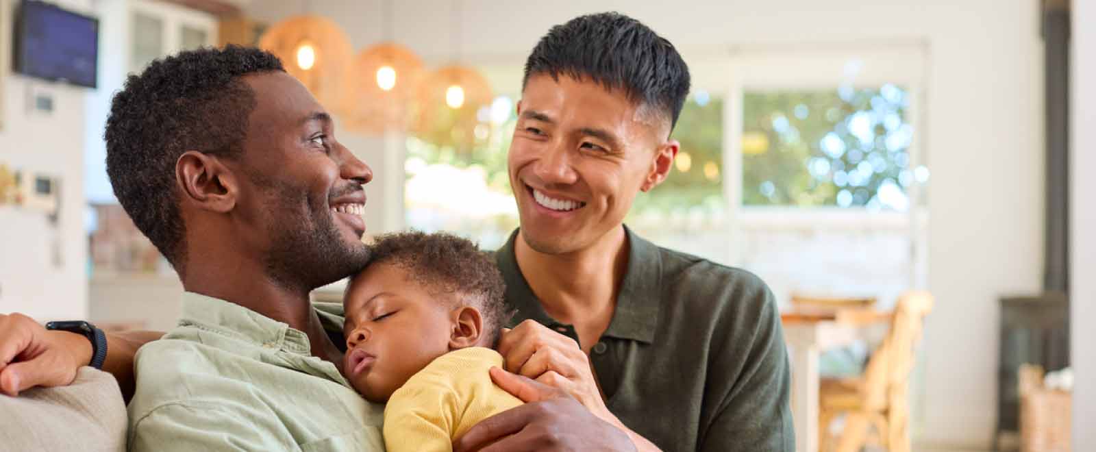 Two fathers holding daughter, feeling financially secure.