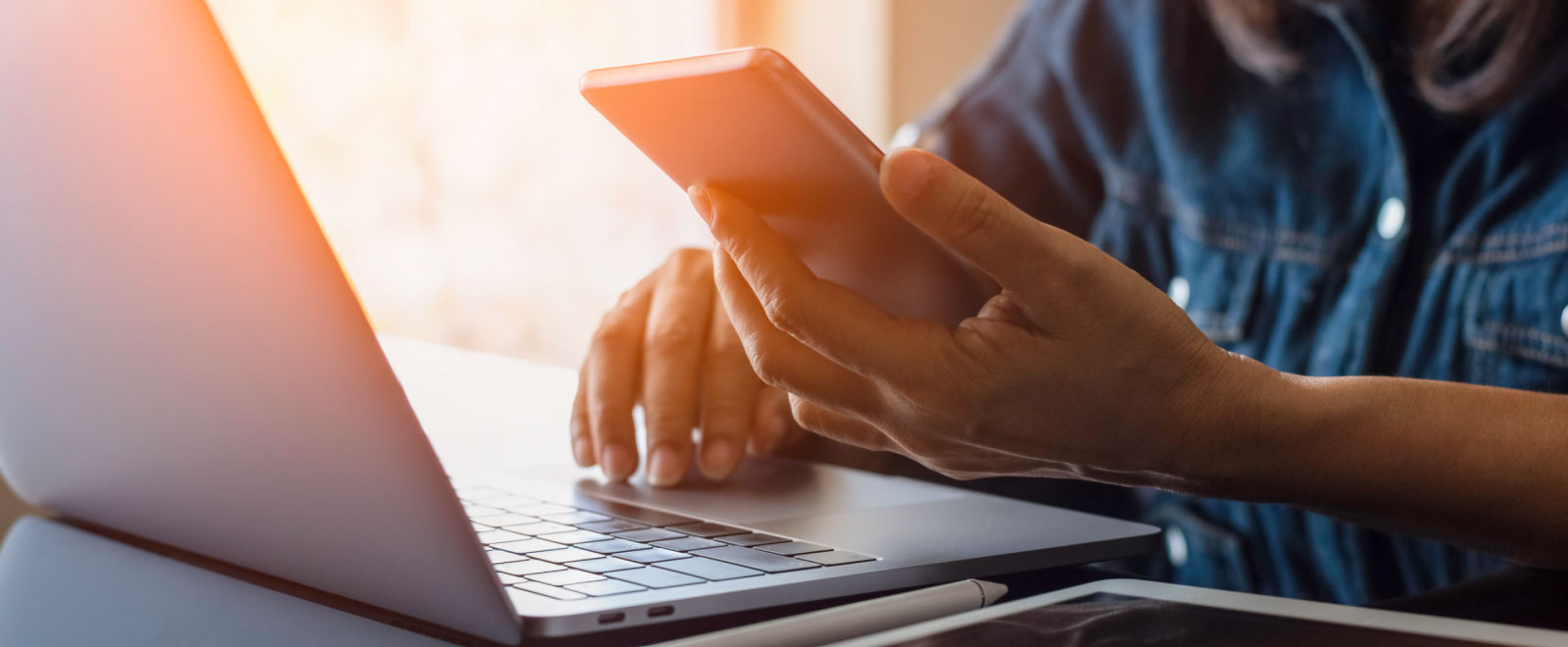 person using laptop, cell phone, and tablet