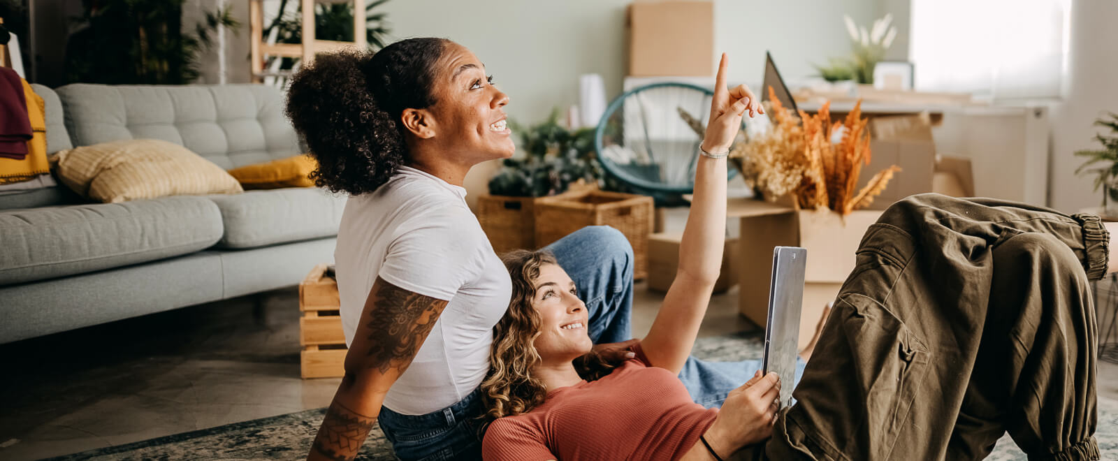 Two women moving in together sit and take in the new home.