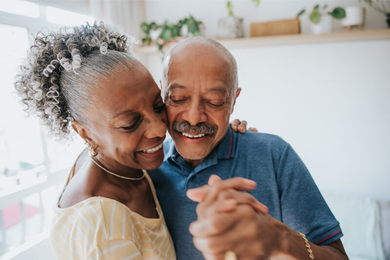 smiling elderly couple dancing
